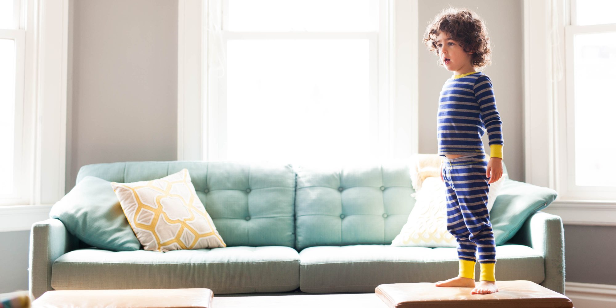 boy standing on a coffee table