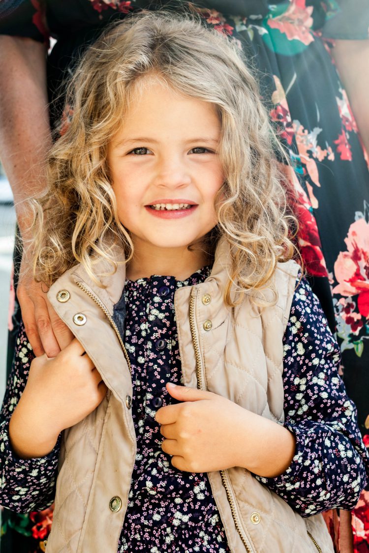 young girl wearing vest and floral shirt