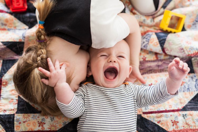 girl making little brother laugh