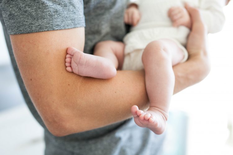 baby feet in dad's arms