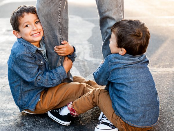 boys holding on to dad's legs