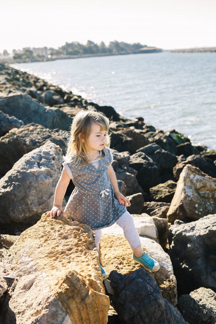 giorl playing on rocks at berkeley waterfront