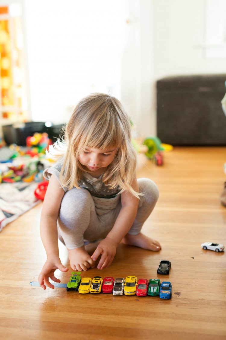 girl playing with toy cars