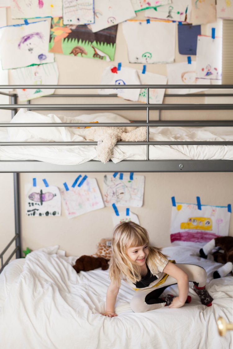 girl on bunkbed with kids wall art