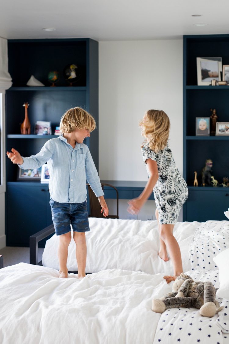 kids jumping on beds in modern home