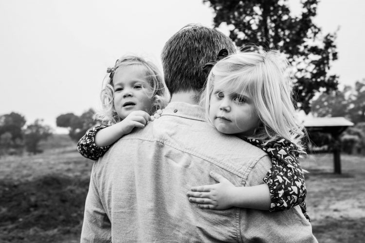 Dad holding twin daughters