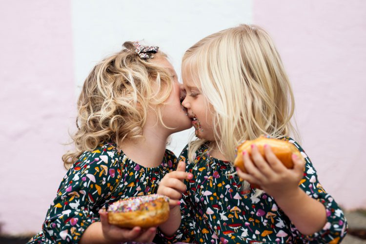 twins girls eating donuts